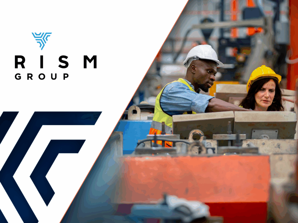 Two people wearing hardhats in factory environment.
