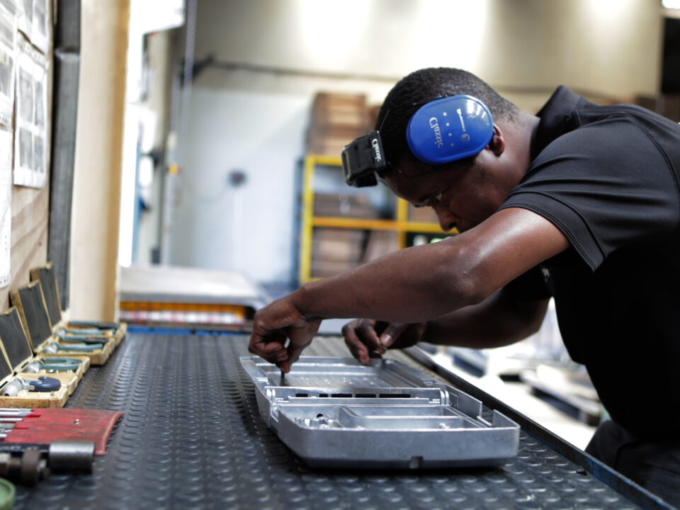 Man with ear dampeners Inspecting die cast alloy parts